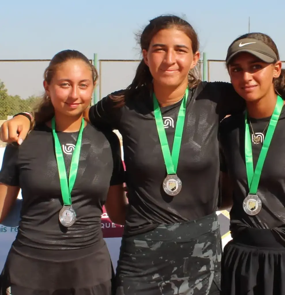 Drie tennisspeelsters dragen Beyond Wear en medailles